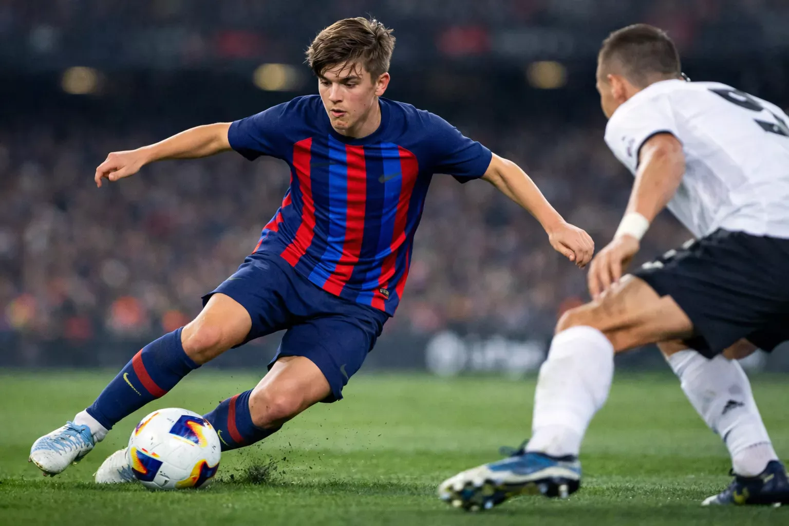 Joven jugador del Barcelona regateando con el balón en un partido